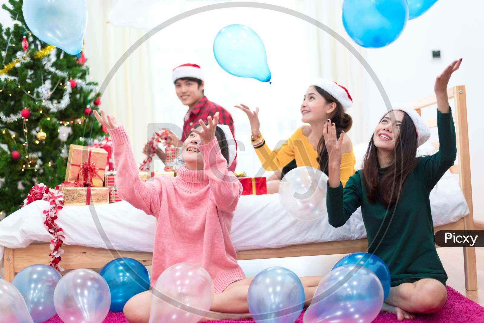 Group Of Asian People Are Throwing The Balloons For Celebrating Christmas And New Year. Holiday And Party Concept