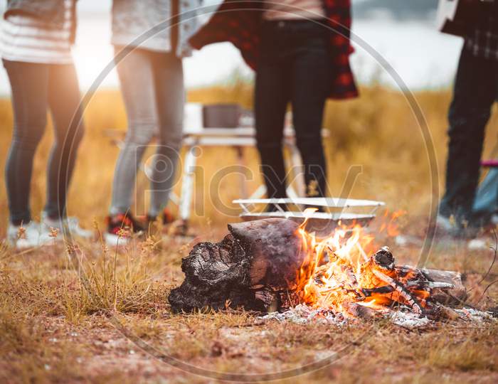 Closeup Of Campfire With Friendship Dancing To Beat Of The Music For Celebrating In Party With Mountain Meadow And Lake View Background. People Lifestyle And Travel Vacation. Picnic And Camping Tent