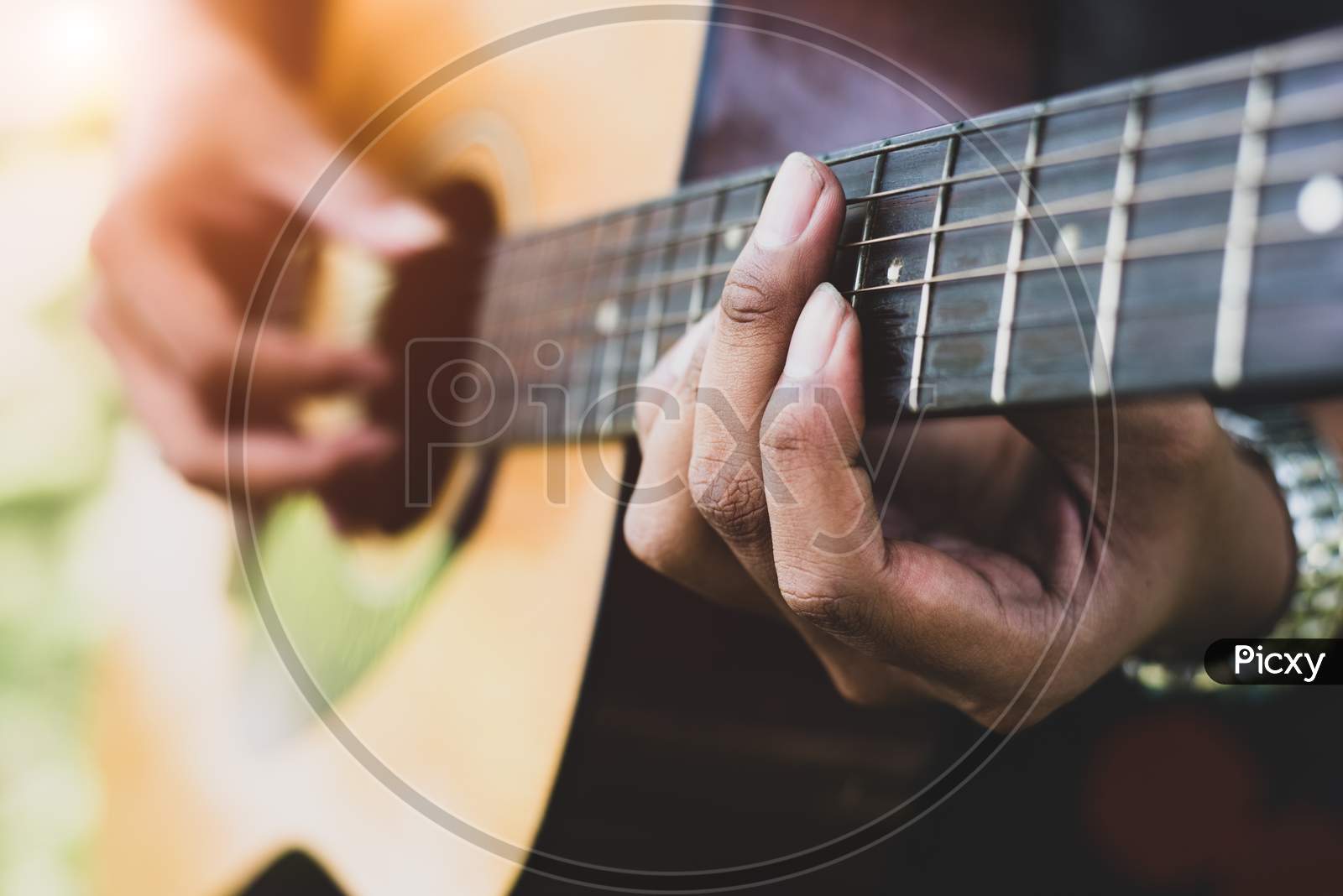 Close Up Of Guitarist Hand Playing Guitar. Musical And Instrument Concept. Outdoors And Leisure Theme. Selective Focus On Left Hand.