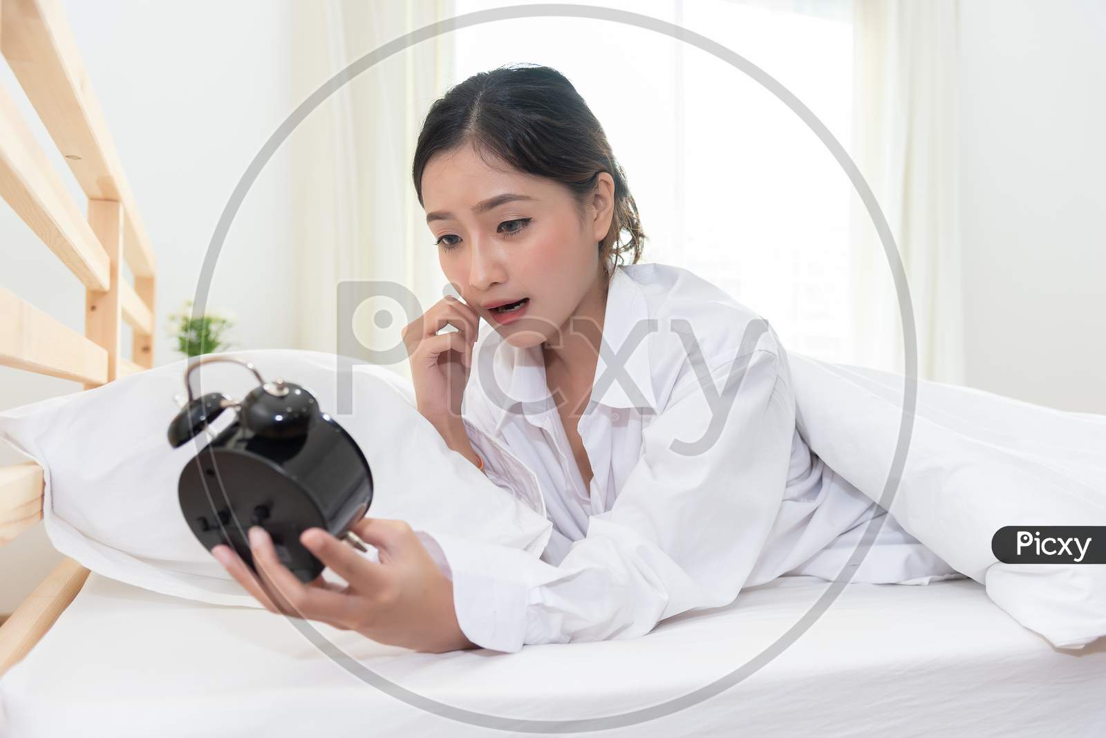 Asian Woman Shocked When Wake Up Late By Forget To Setting Alarm Clock At Night And Having Meeting Appointment And Working In Morning Today. People Lazy And Hurry Up Rush Hour Concept. Shocked Agape