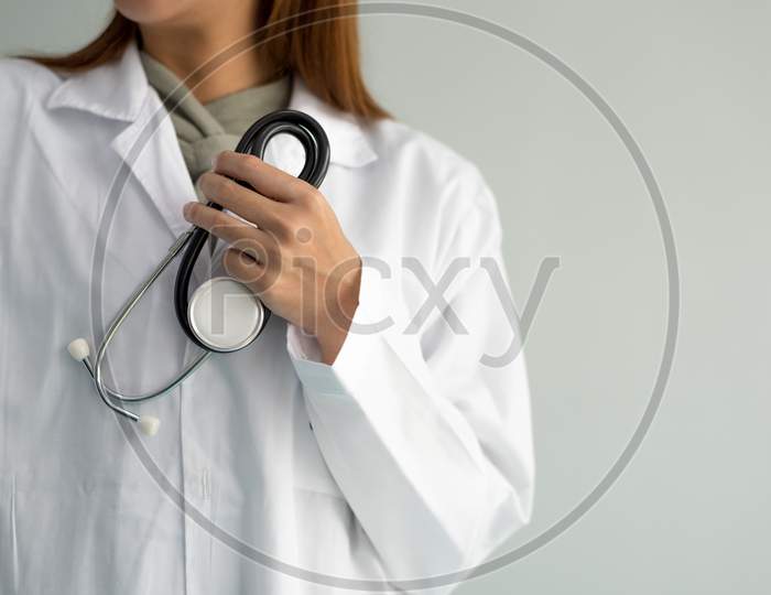 Female Doctor Is Holding Stethoscope And Hear Heart Beat Sound On White Background. Medical And Healthcare Concept. Hospital And People Theme