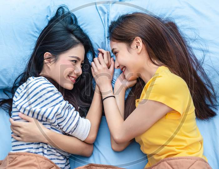 Two Asian Womens Looking At Each Others When Lying On Bed. Lifestyles And Lovers Concept. Happiness Life And Relax Concept. Homosexual Life Theme. Lgbt Pride And Lesbian Couples Theme.