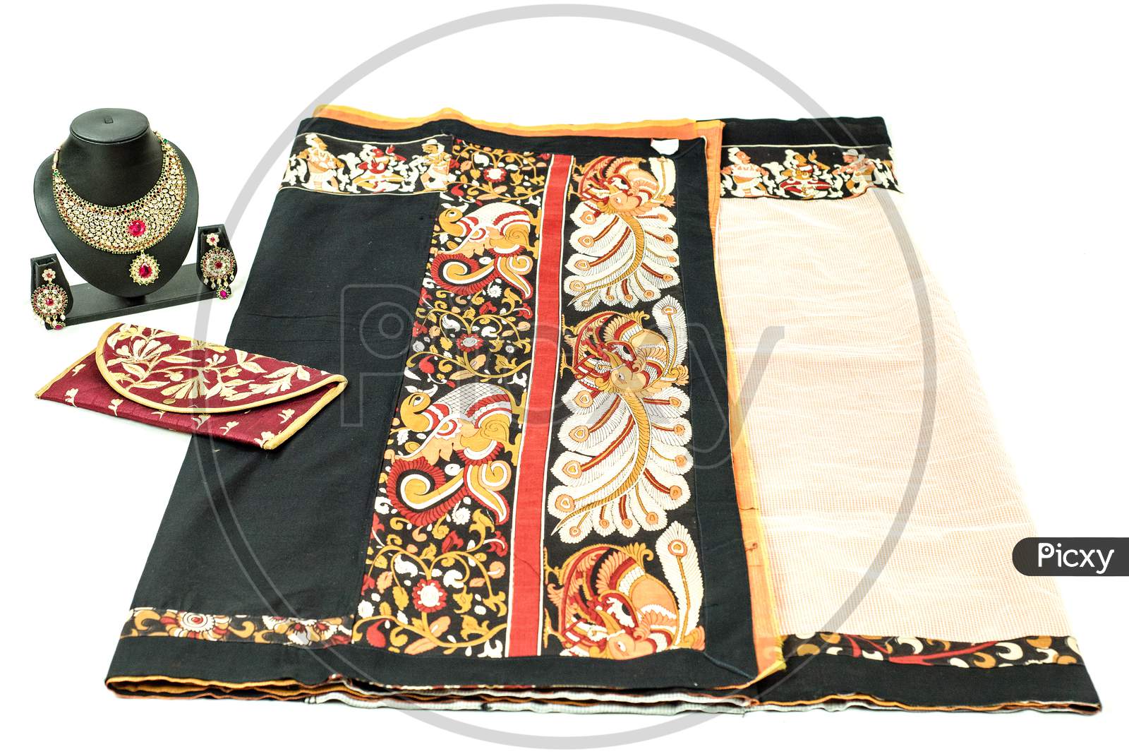 Folded black and red colour fabric  placed on a white  background kept with a Indian Jewelries