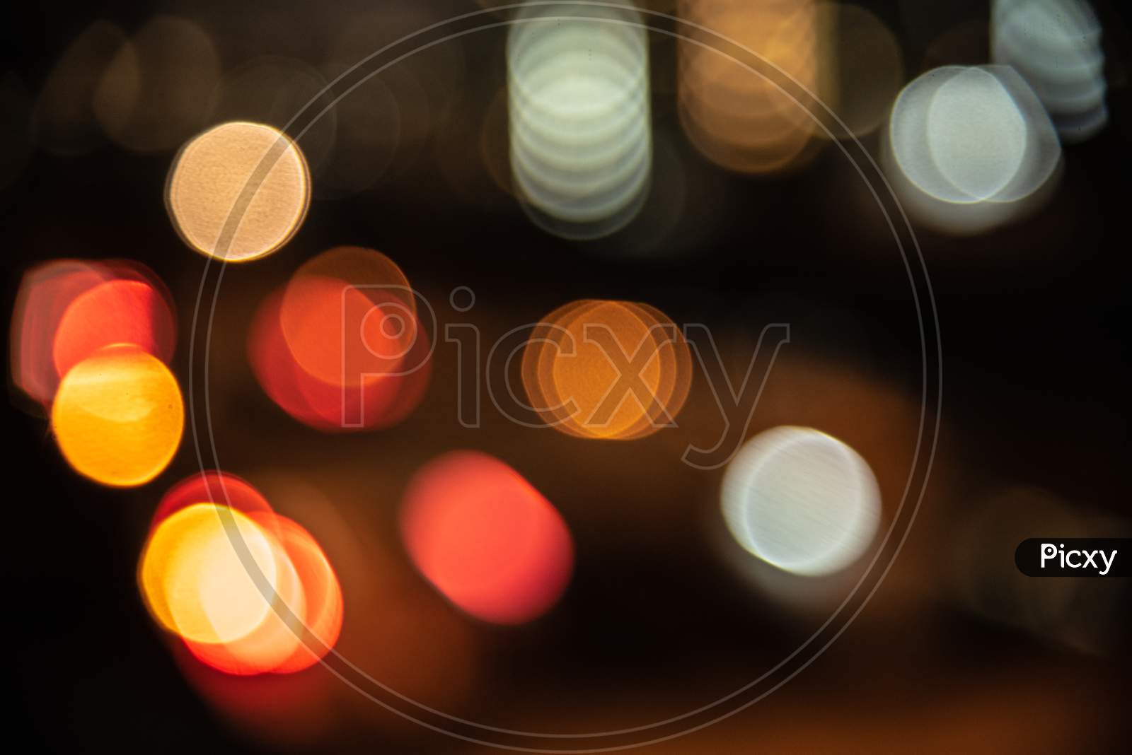 Blurry Background Of City Light In The Nightlife. Abstract And Wallpaper Concept. Traffic And Metropolis Theme. Defocused Photo
