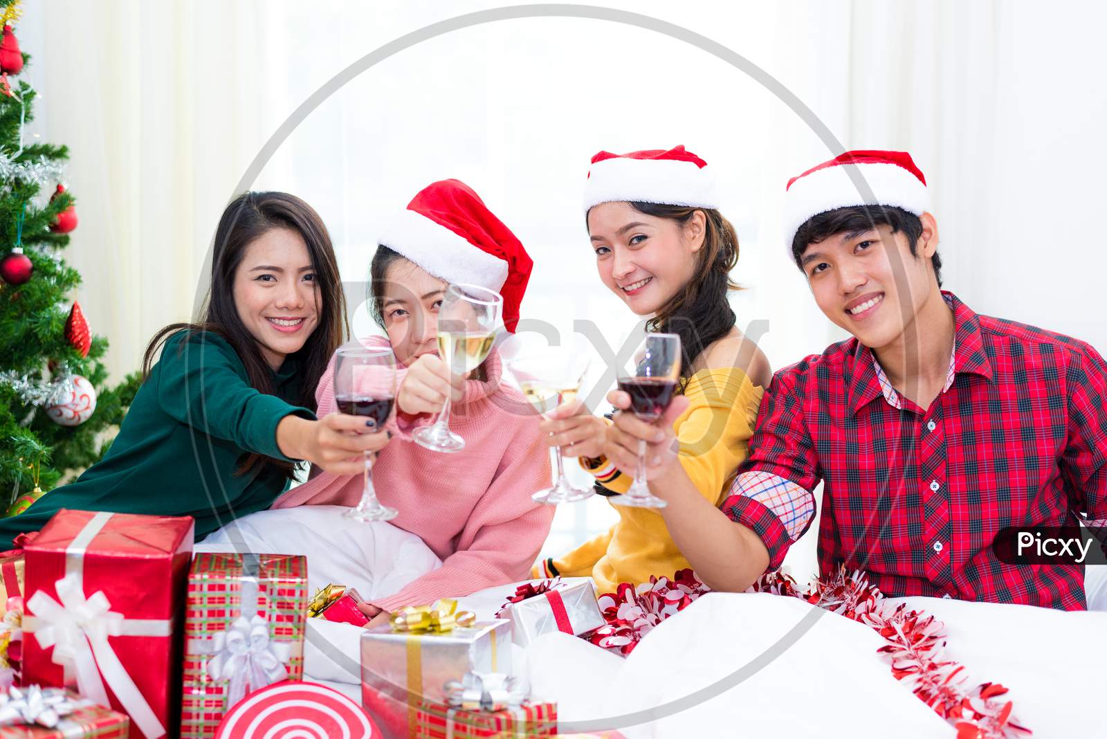 Group Of Young Asian People Celebrating New Year Party In Home With Wine Drinking Glasses. New Year And Christmas Party Concept. Happiness And Friendship Concept. Relation And Funny Together Theme.