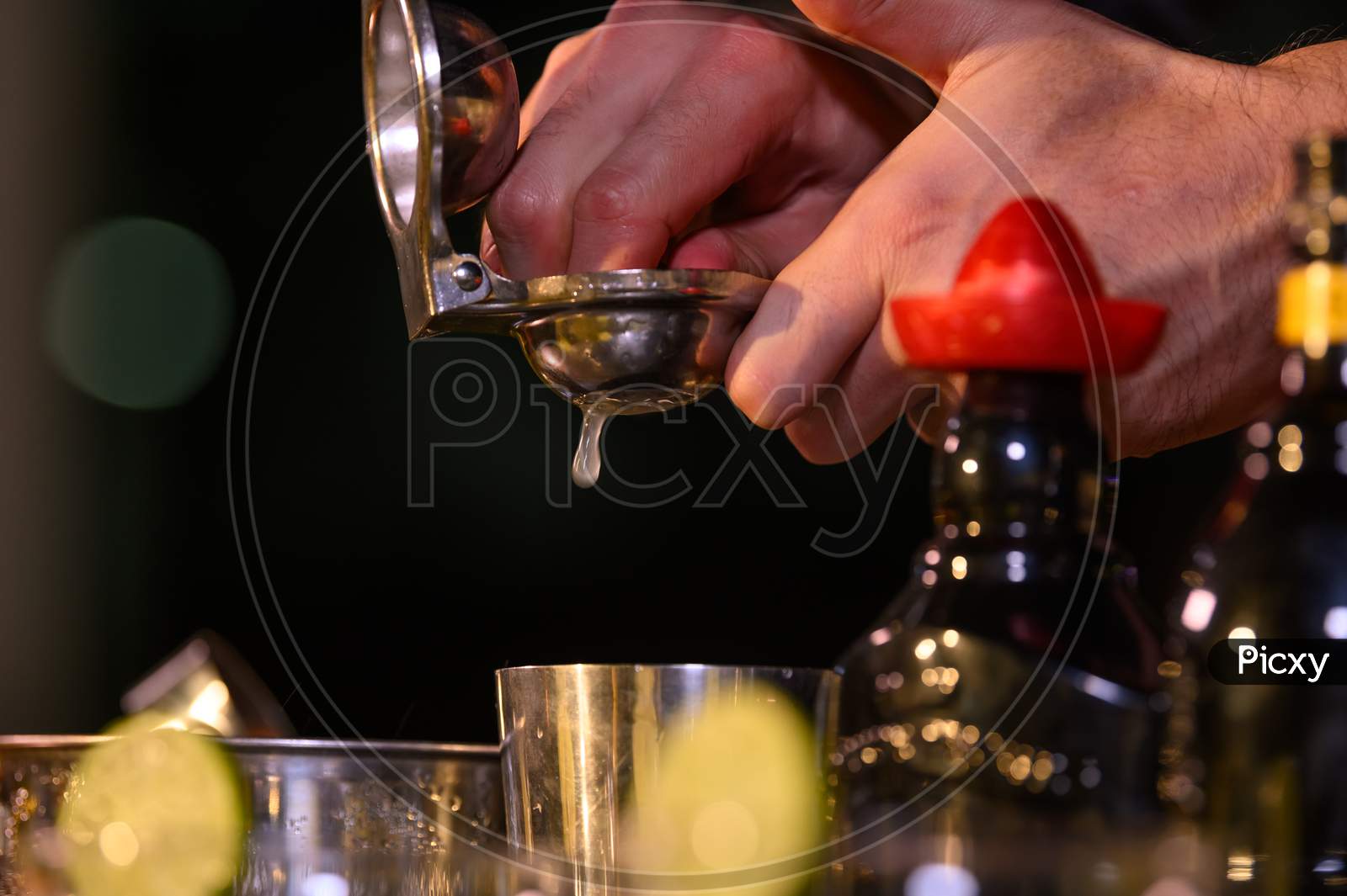 Closeup Bartender Hand Preparing Fresh Juice Cocktail In Drinking Wine Glass With Ice At Night Bar Clubbing Counter. Occupation And People Lifestyles Concept. Outdoor And Nightclub Background