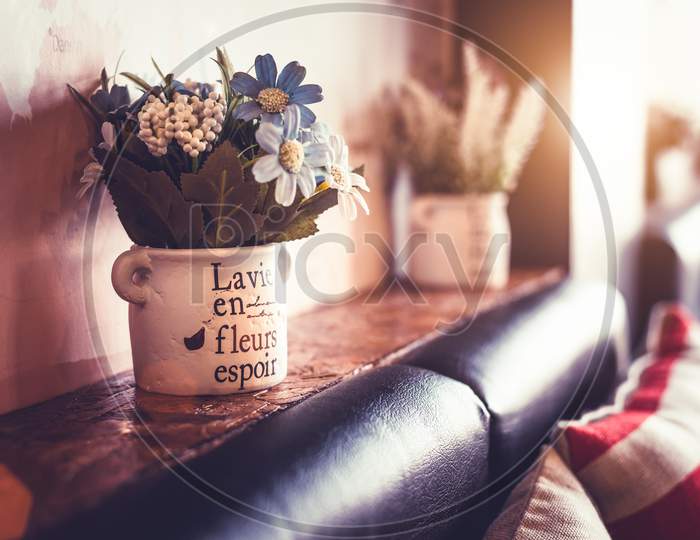 Flower Vase With Sofa And Pillow In Coffee Shop And Restaurant. Gardening Decoration And Interior Concept. Vintage Warm Tone Film.