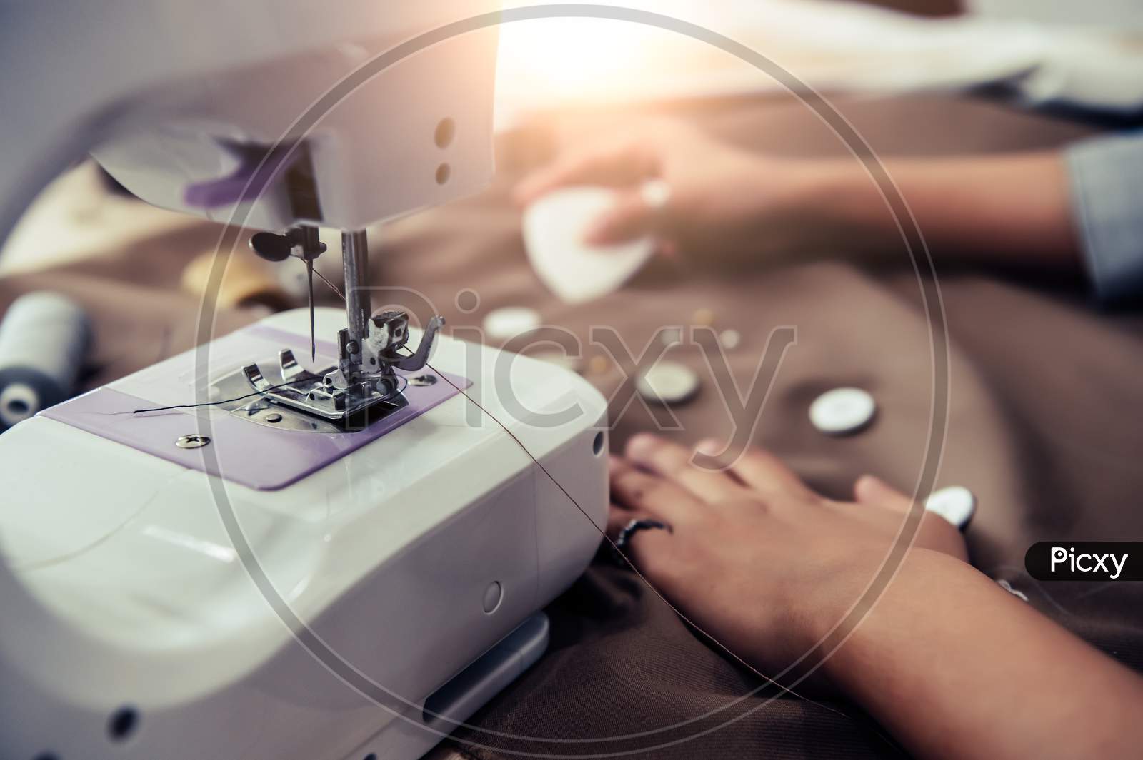 Closeup Of Sewing Machine With Dressmaker Designing New Fashion Dress Fabric Background. Fashion Designer Tailor Or Sewer In Workshop Designing New Collection Cloth. Business Owner And Entrepreneur