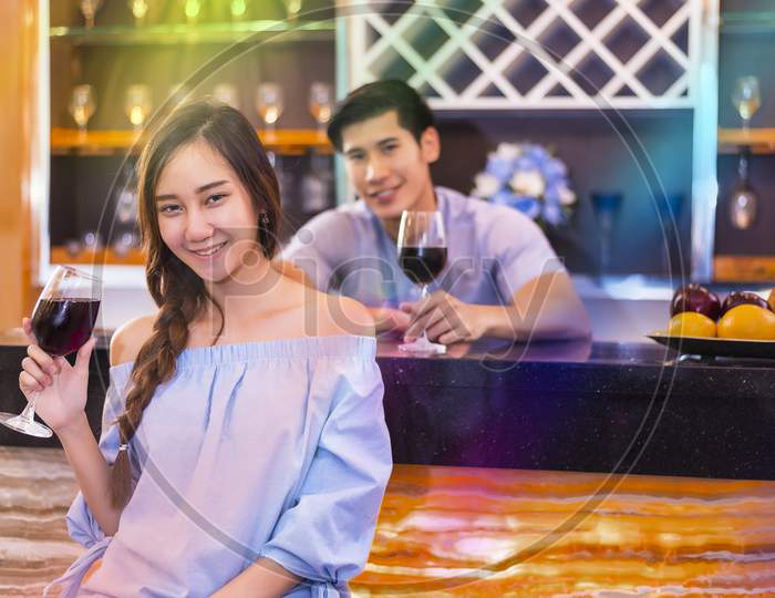 Lovers Smiling And Drinking For Honeymoon At Bar. Couple And Relax Concept. Night Honeymoon Theme