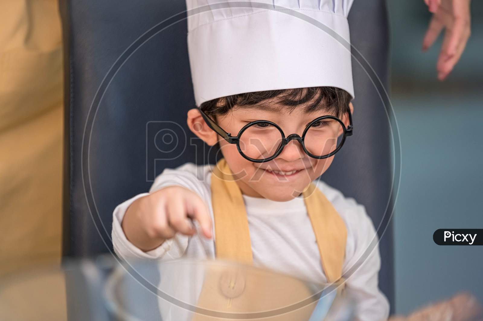 Portrait Cute Little Asian Happy Boy Interested In Cooking With Mother Funny In Home Kitchen. People Lifestyles And Family. Homemade Food And Ingredients Concept. Baking Christmas Cake And Cookies