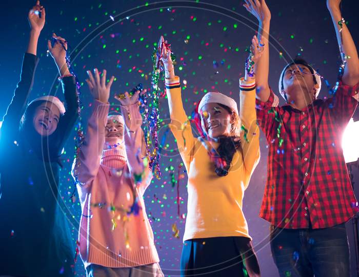 Group Of Asian People Celebrating New Year Party In Night Club With Confetti. New Year And Christmas Party Concept. Happiness And Entertainment Concept. Night Pub And Night Life Theme. New Year 2018