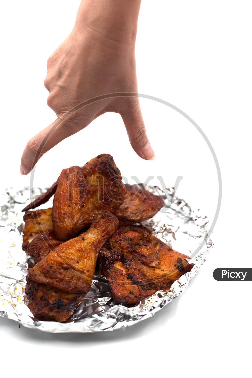 Hand Catching Roasted Wing. Delicious Grill Chicken On Foil On Isolated White Background. Food And Appetizer Concept