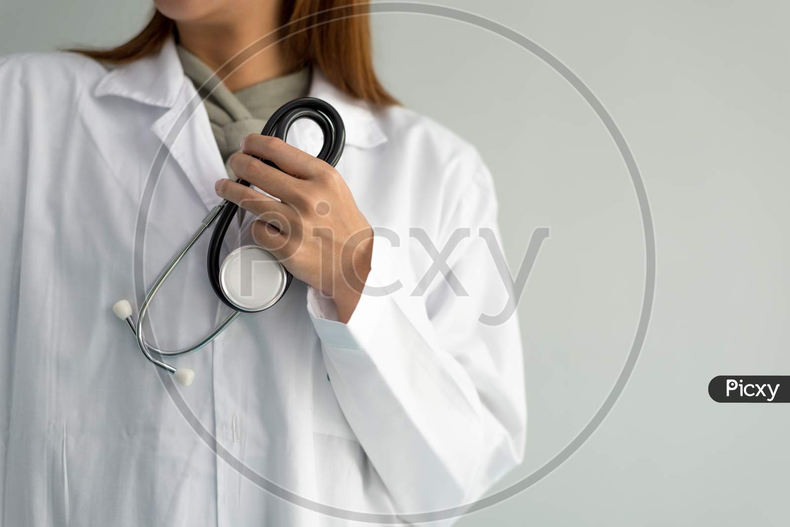 Female Doctor Is Holding Stethoscope And Hear Heart Beat Sound On White Background. Medical And Healthcare Concept. Hospital And People Theme