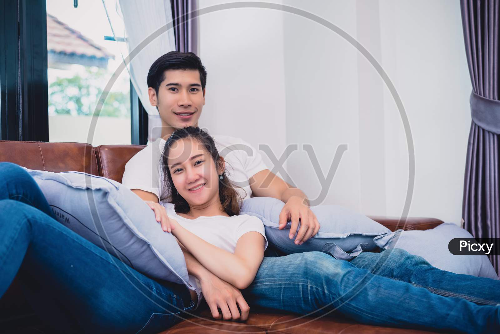 Asian Young Couples Relaxing On Sofa. Lovers And Couples Concept. Honeymoon And Wedding Theme. Interior And Dating Theme.