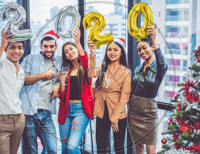 Group Of Diversity Colleague Teamwork Celebaring For New Year Party 2020 In Modern Urban Office Background. Friends Having Enjoy Party With Alcoholivd Drinks Together. Multi Ethics People Lifestyles.