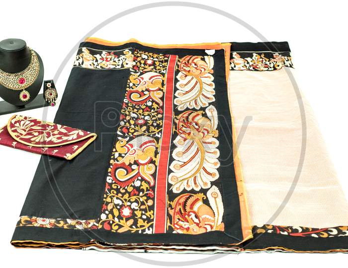 Folded black and red colour fabric  placed on a white  background kept with a Indian Jewelries