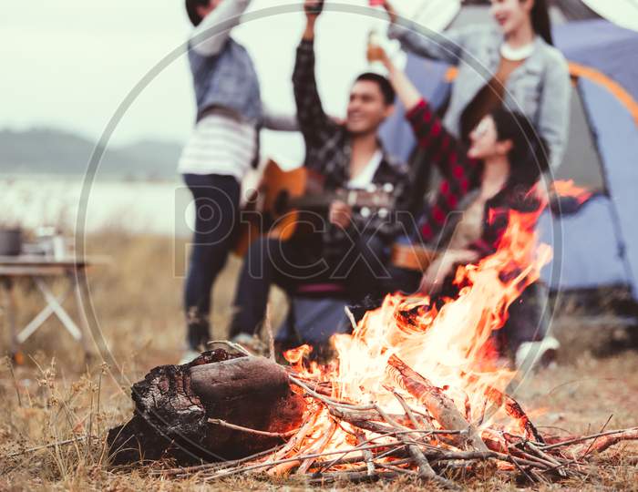 Closeup Of Bonfire And Friendship Clinking Drinking Bottle Glass For Celebrating In Party With Mountain Meadow And Lake View Background. People Lifestyle And Travel Vacation. Picnic And Camping Tent