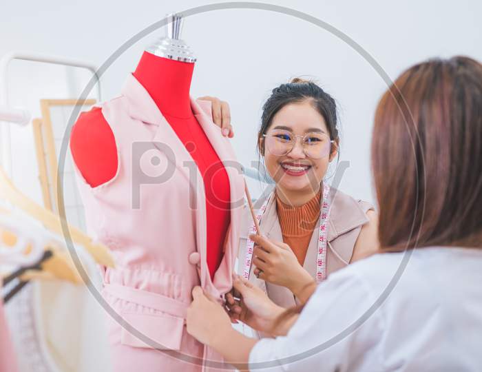 beautiful tailor women smiling when measure the mannequin chest