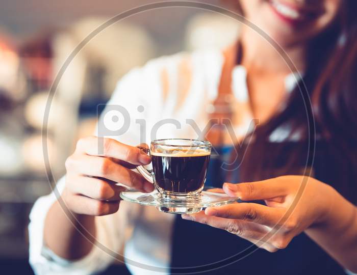 Closeup Of Coffee Cup With Beautiful Asian Woman Barista Background For Making Coffee To Serving To Customer. Job And Occupation. Food And Drink Beverage. Coffee Shop And Cafe. Business And Restaurant