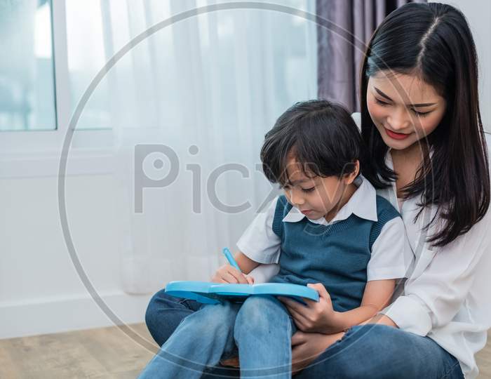 Asian Mom Teaching Cute Boy To Drawing In Chalkboard Together. Back To School And Education Concept. Family And Home Sweet Home Theme. Preschool Kids Theme.