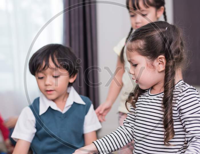 Group Of Kids Playing Together And Have Conflict About Toy In Home. Little Girl Angry To Boy. Education And Learning Concept. Lifestyles And Kids Development Theme.