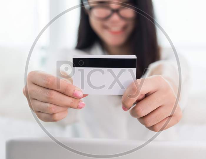 Young Asian Woman Use Credit Card For Online Shopping With Laptop. Business And Banking Payment Concept. Price Sale And Promotion Concept. Technology And Computer Theme. E-Commerce And Marketing Theme