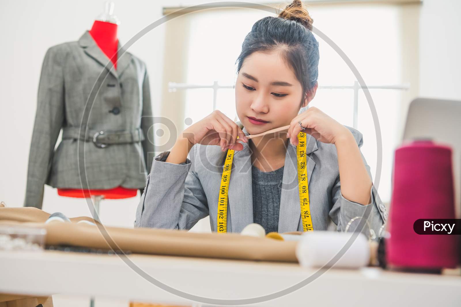 Attractive Asian Female Fashion Designer Working In Home Office Workshop. Stylish Fashionista Woman Creating New Cloth Design Collection. Tailor And Sewing. People Lifestyle And Occupation Concept