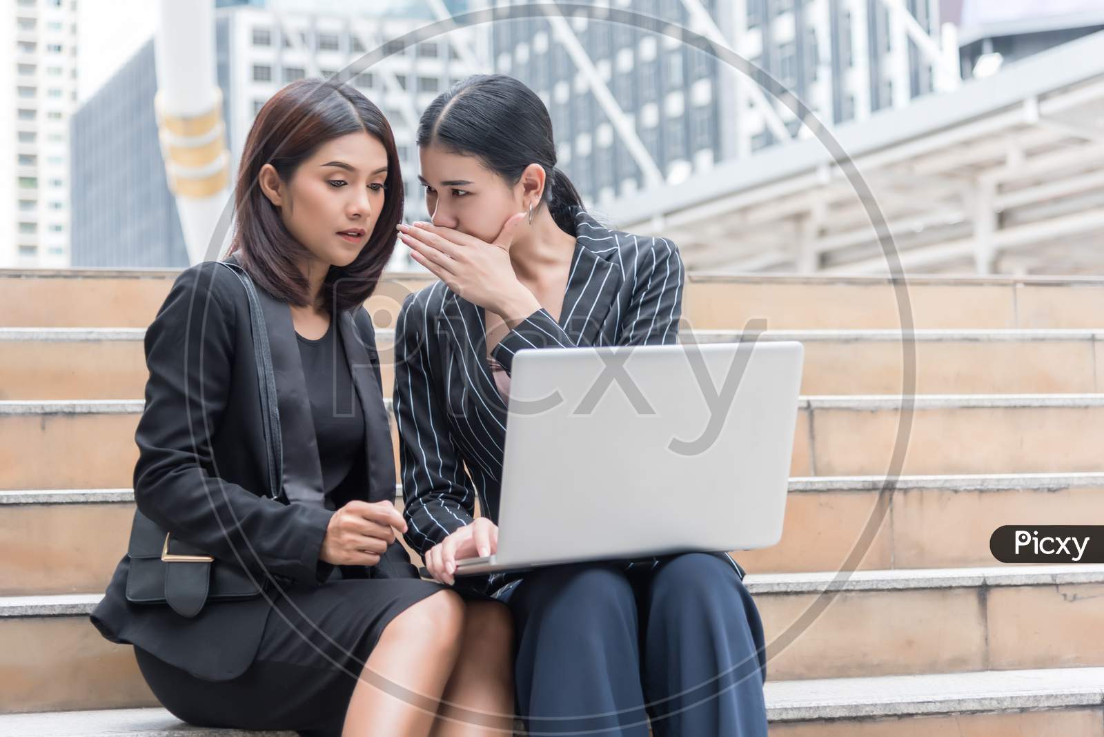 Business Women Gossip While Using Laptop At Outdoor. Business And Coworker Concept