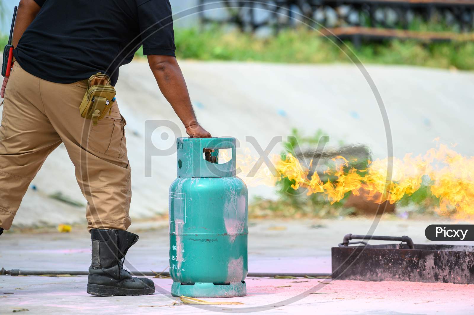 Closeup Of Firefighters Lower Body Training For Fire Drill By Demonstrate How To Close The Gas Tank Valve Correctly. Security Insurance Protection And Fire Fighter Concept. Occupation And Volunteer