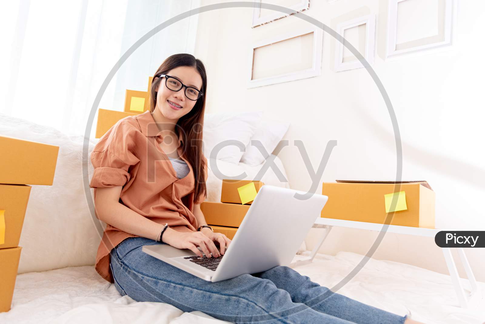 Beauty Asian Woman Using Laptop For Customer Support In Bedroom. Business Technology Concept. Delivery Online Shopping. Service. People Lifestyle Remote Work In Domestic House. Looking At Camera