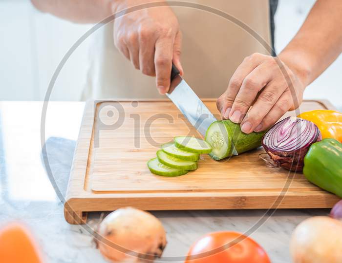 Close Up Of Man Hand Cooking And Slicing Vegetable In The Kitchen For Preparing Dinner With His Wife When Coming Home. People And Lifestyles Concept. Food And Drink Theme.
