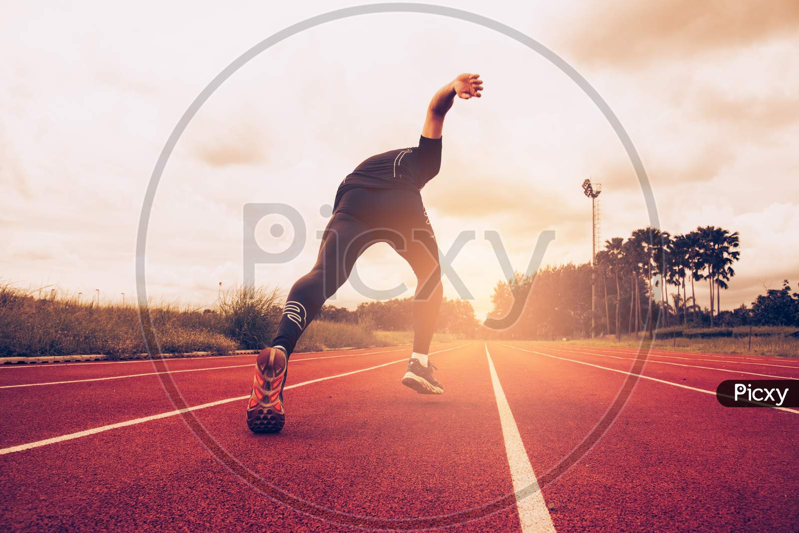 Sunset And Young Man Running On Lane. Success And Goal Of Business Concept. Sport Athletic And Exercise Theme.