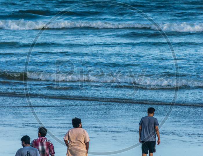 Friends going towards the blue wavy sea . Bay of Bengal