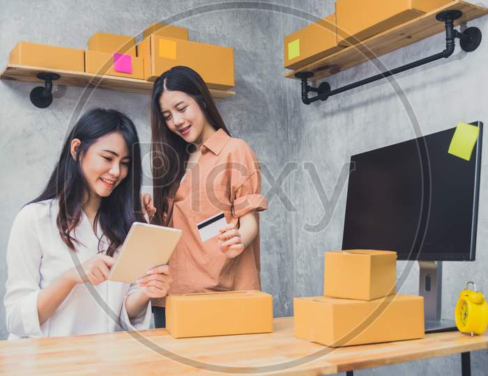 Two Young Asian People Startup Small Business Entrepreneur Sme Distribution Warehouse With Parcel Mail Box. Small  Owner Home Office. Online Marketing And Product Packaging And Delivery Service