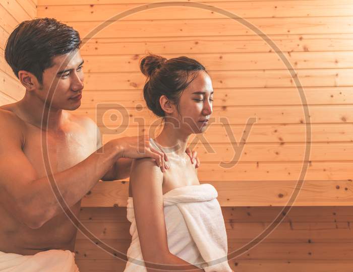 Young Asian Couples Or Lovers Have Romantic Relaxing In Sauna Room. Skin Care Heat Treatment And Body Clean Up And Refreshing In Spa With Steam Bath. Healthy And Honeymoon Concept. Happiness Together