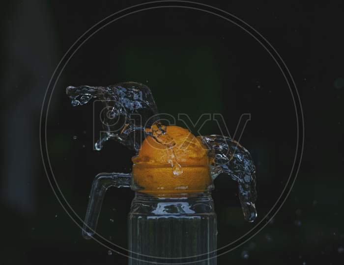 Water splash photography with Orange fruit.