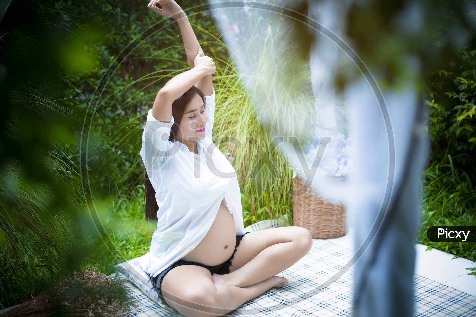 Pregnant Woman Doing Yoga At The Outdoor