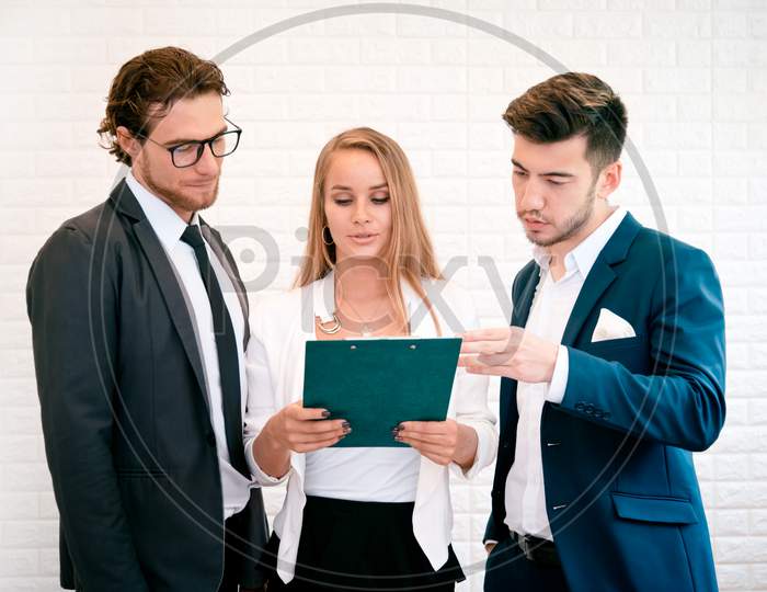 Three Business People Are Looking At The Summary Report And Consult Together, Indoors  Businessman And Businesswoman Concept, Meeting And Consulting Concept