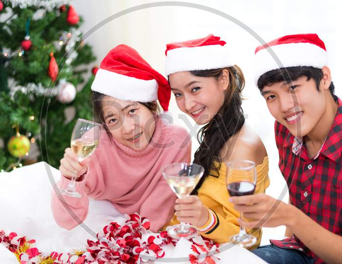 Group Of Young Asian People Celebrating New Year Party In Home With Wine Drinking Glasses. New Year And Christmas Party Concept. Happiness And Friendship Concept. Relation And Funny Together Theme.