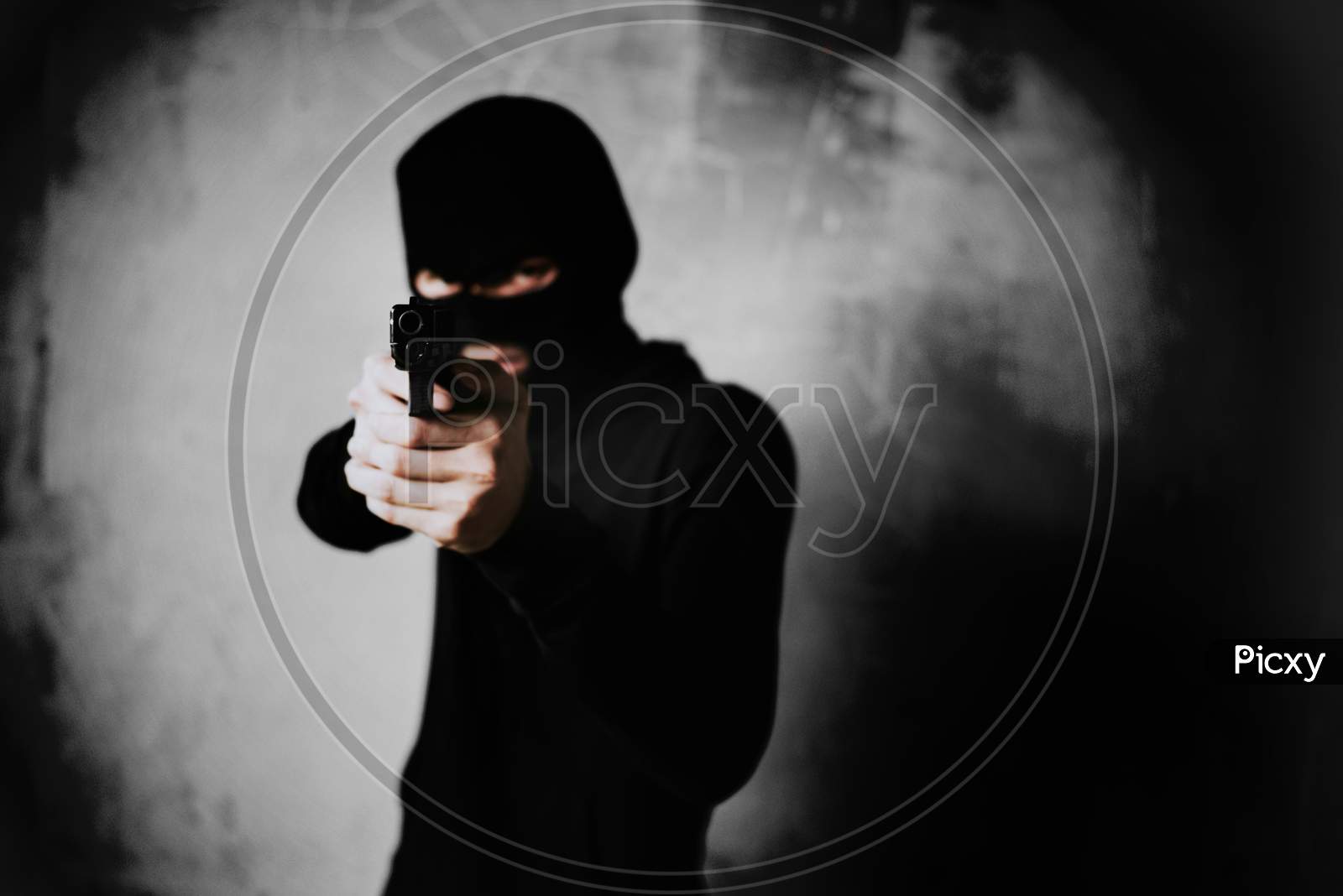 Terrorist Shooting With His Mini Gun Weapon With Grunge Room Wall Background. Criminal And Dangerous Illegal People Concept. Terrorist And War Theme. Dark Tone And High Contrast Use