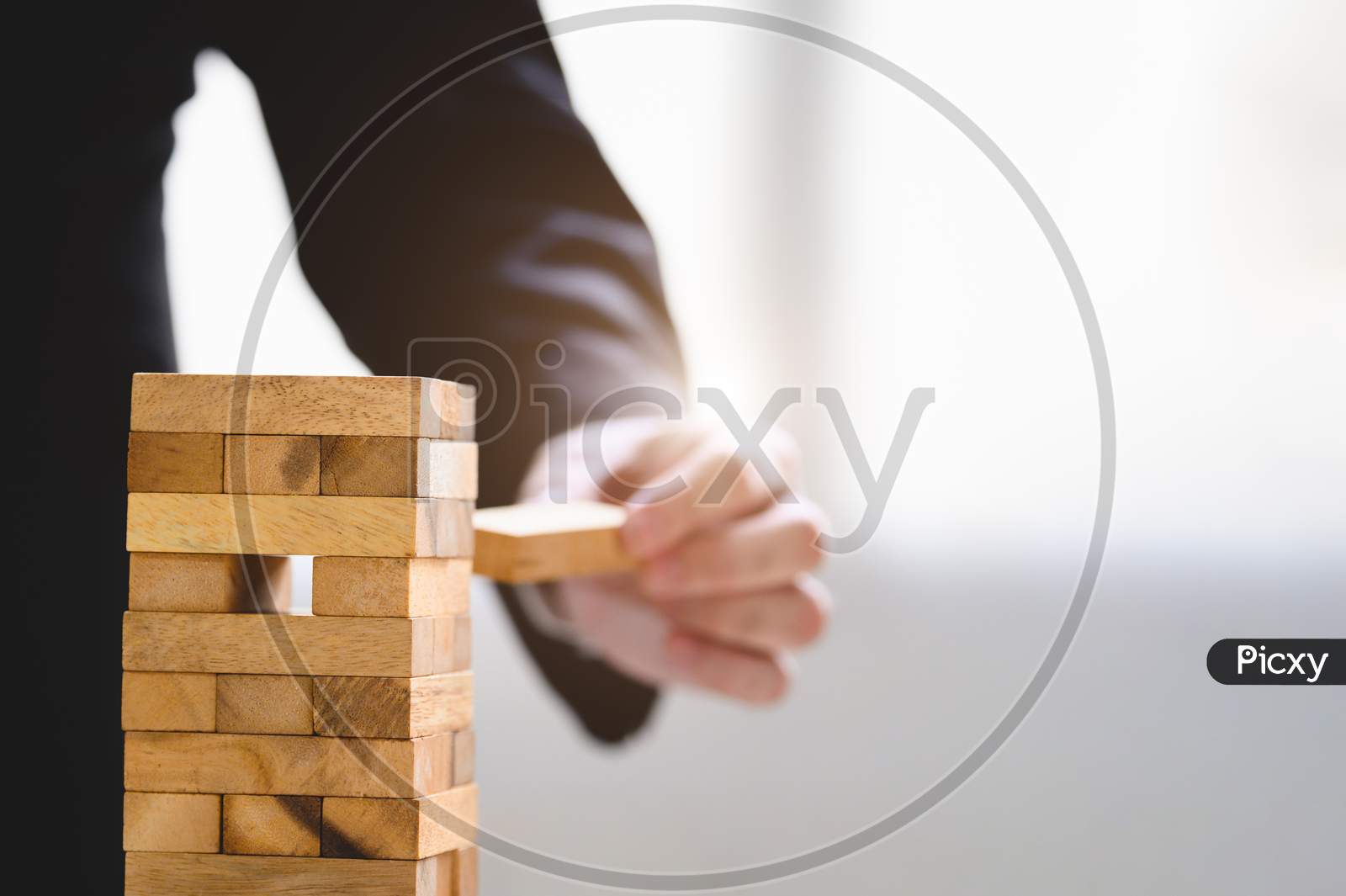 Businessman Take And Picking One Wood Block On Stacked Tower By Hand As Startup Project. Business Organization And Company Growth Progress. Success Of Strategy And Money Investment. Risk Management