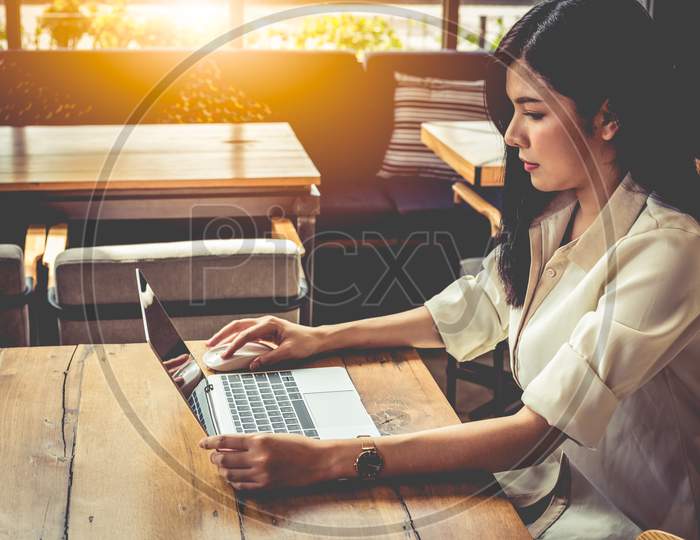 Asian Woman Working With Laptop In Coffee Shop. People And Lifestyles Concept. Outdoors Working And Freelance Theme.