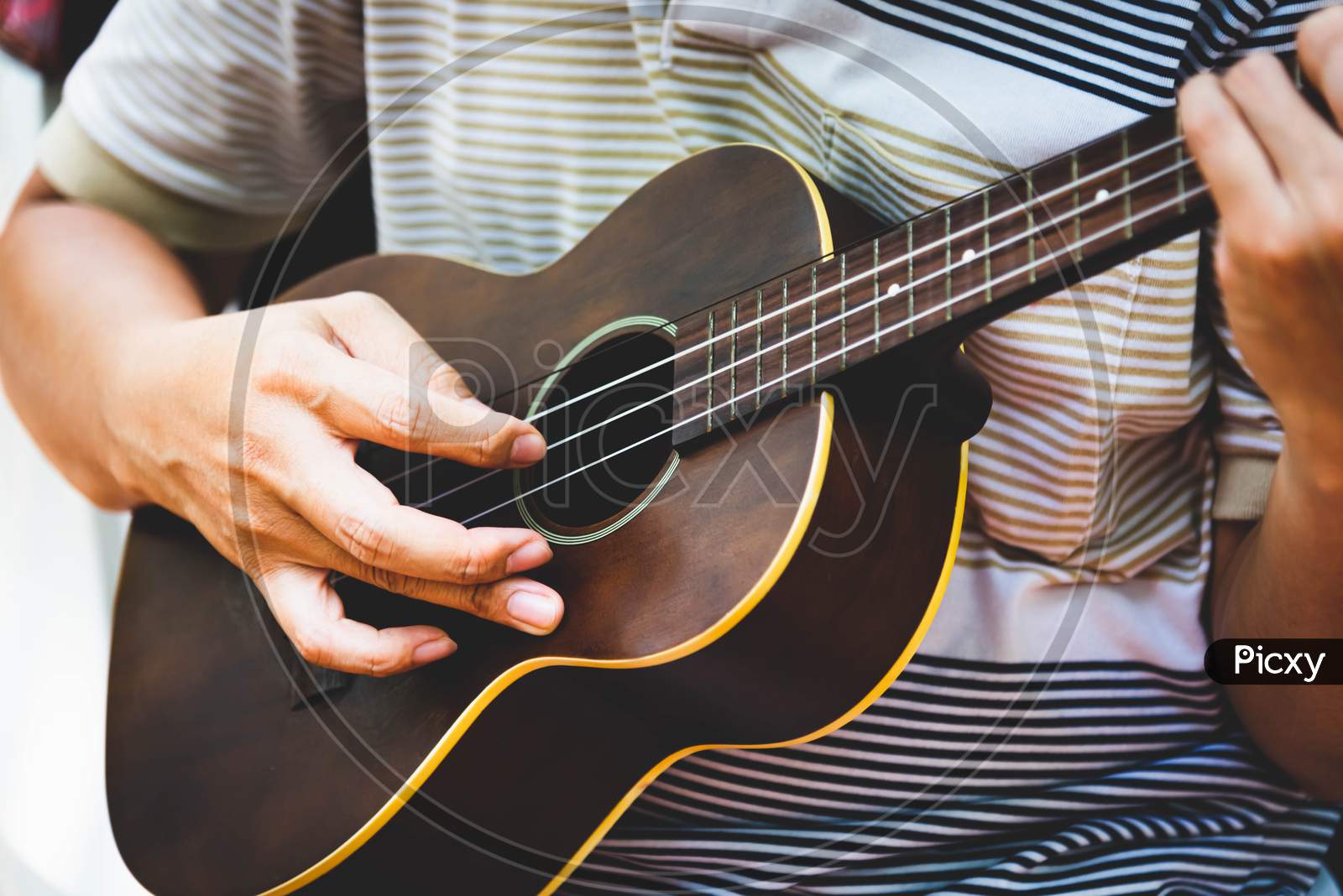 Closeup Of Guitarist Hand Playing Guitar. Musical Instrument Concept. Outdoors And Leisure Theme. Selective Focus On Left Hand. Vintage Country Folk Guitar With Music Singer. Close Up Entertainer Hand