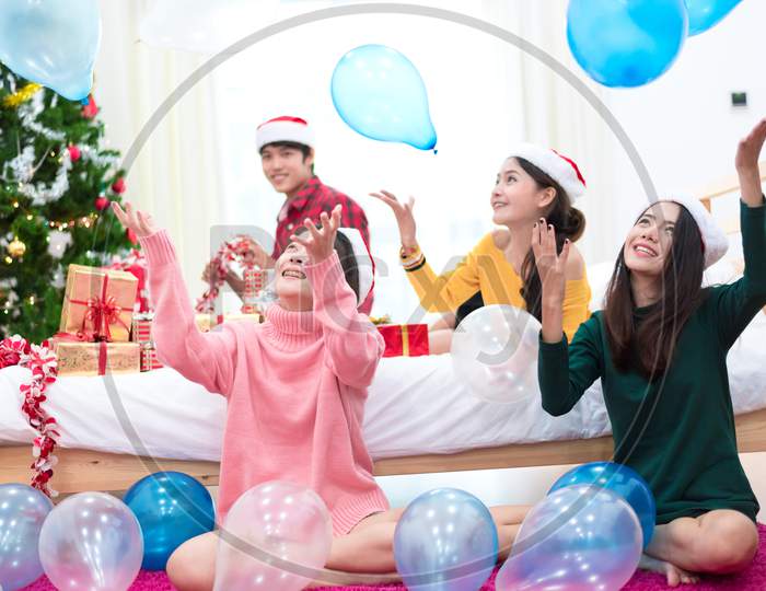 Group Of Asian People Are Throwing The Balloons For Celebrating Christmas And New Year. Holiday And Party Concept