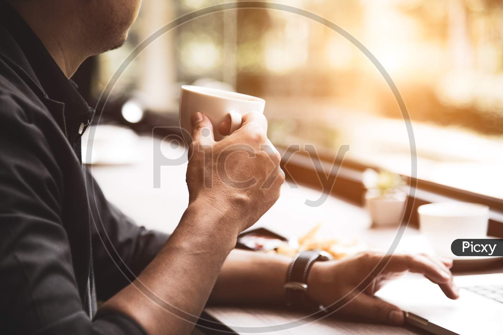 Close Up Of Coffee Cup On Businessman Hand. Man Working With Laptop Computer. Business And Technology Concept. Workaholics And Overnight Theme. Drinks And Relaxation Theme.