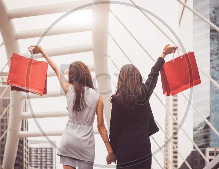 Shopaholic Lifestyle Friendship Women Holding Shopping Bag In Shopping Mall Center. Black Friday And Cyber Monday Sale Concept. Rich And Luxury Buyer Having Money For Purchase Wanted Item Or Cosmetic.