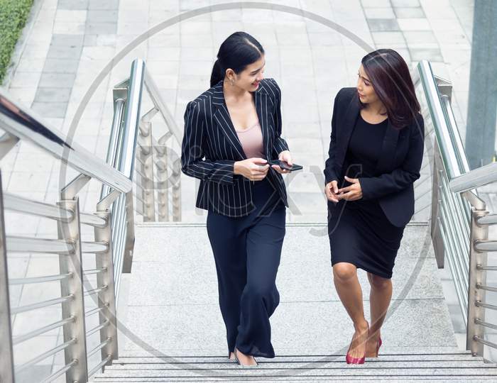 Two Businesswomen Walking Up On Stair And Talking Together. Business And Work Concept. Job And Occupation Concept.