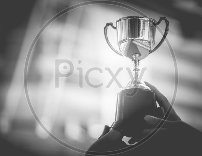 Black And White Trophy With City Background. Success And Achievement Concept. Sport Game And Award Theme. Monochrome Color Theme.