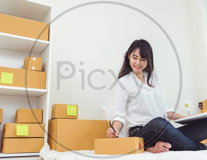 Beauty Asian Woman Using Laptop And Start Up Small Business Entrepreneur Sme And Checking Order List In Bedroom, Young Happy Freelance Woman Shopping Online Marketing Or Sending Parcel To Customers