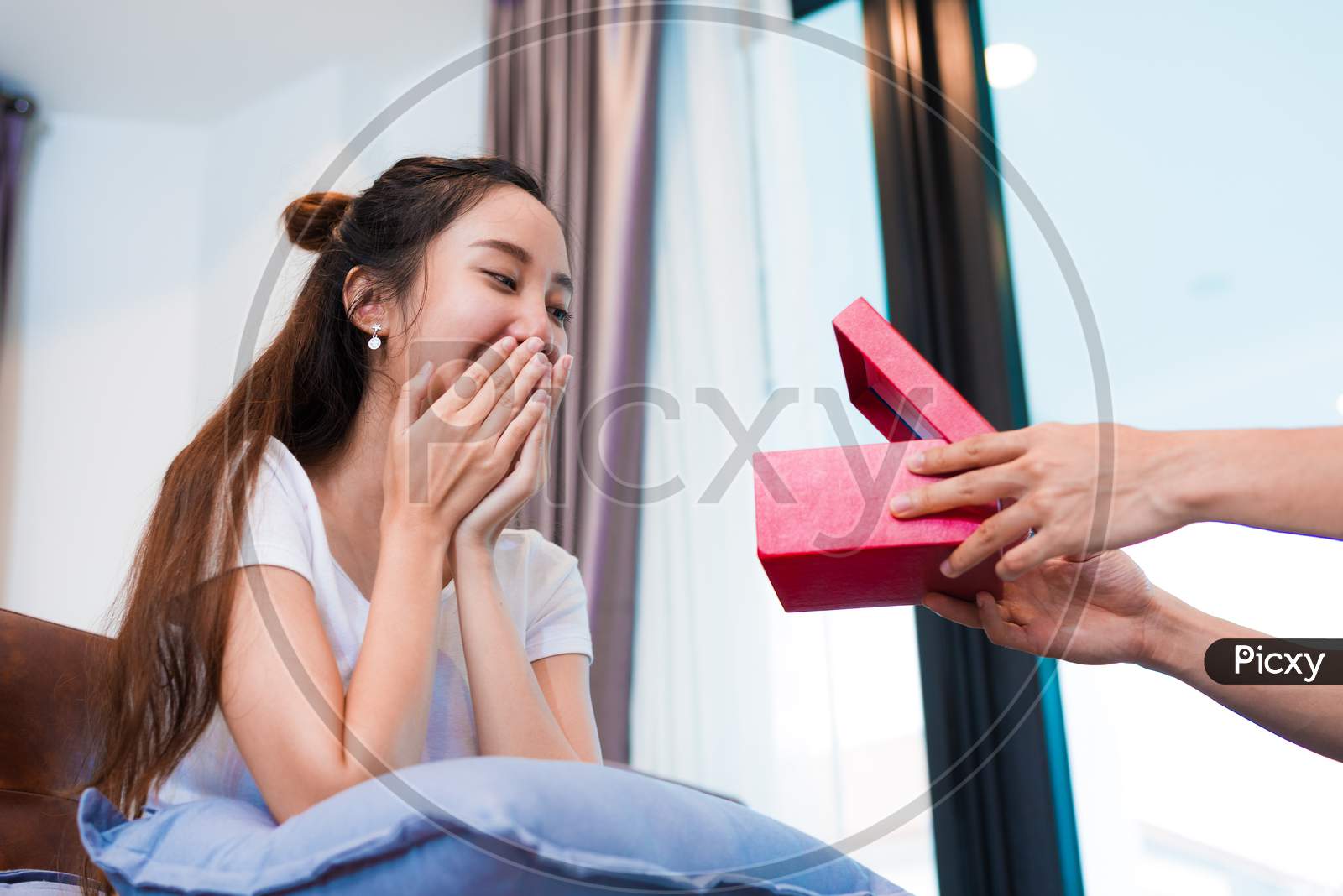 Woman Surprised When Looking At Gift Box On Special Day. Lovers And Honeymoon Concept. Happiness And Valentines Day Theme.